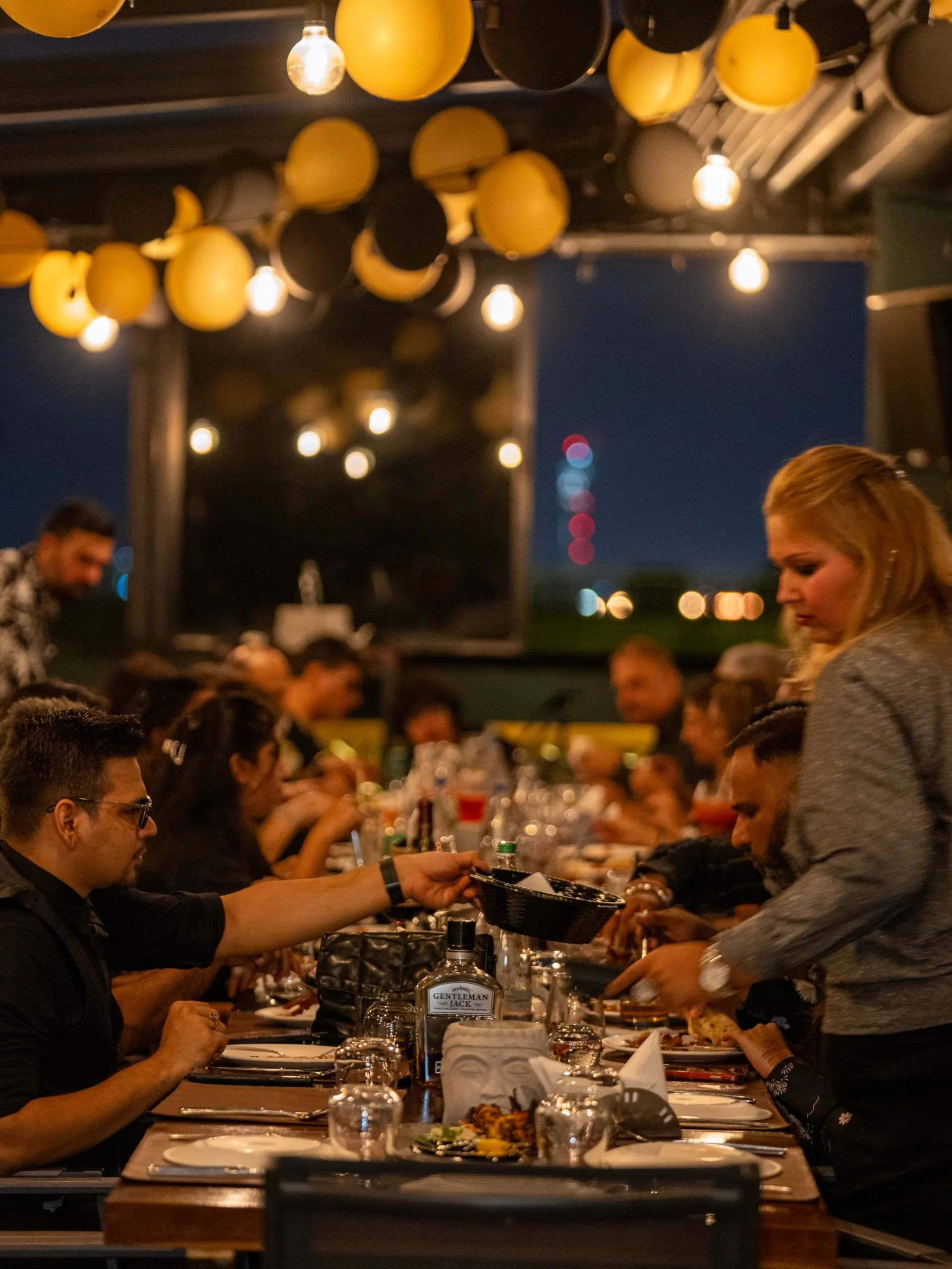 Guests sharing dinner beneath the warm lights at Skyline